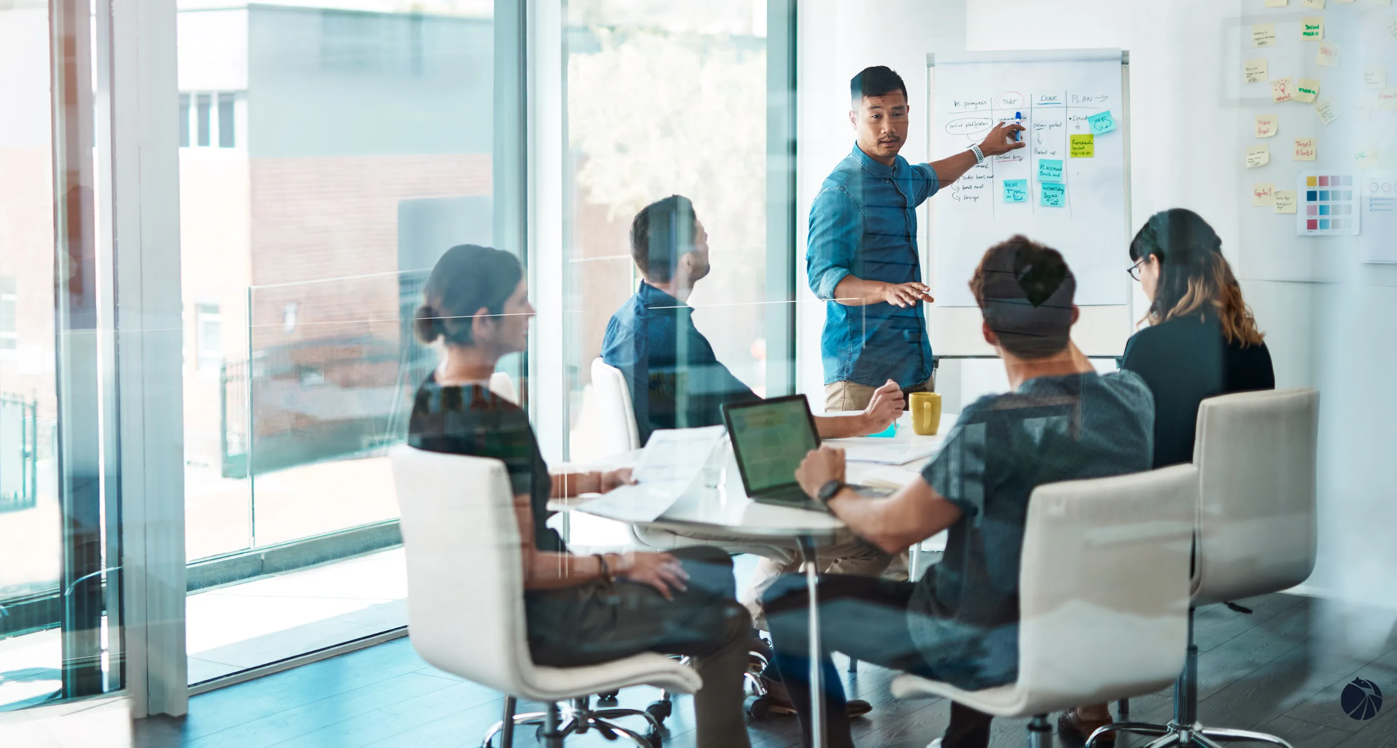 A cohort of operations leaders working through a session at a whiteboard.